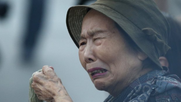 A woman prays for the atomic bomb victims in front of the cenotaph for the victims of the 1945 atomic bombing, at Peace Memorial Park in Hiroshima, western Japan, on Thursday.