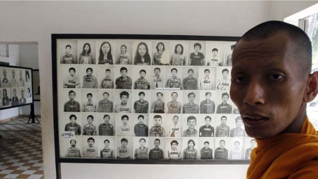 Too gruesome to publish ... a distressed Buddhist monk looks at the portraits of some of the thousands of victims who died in Tuoi Sieng prison.