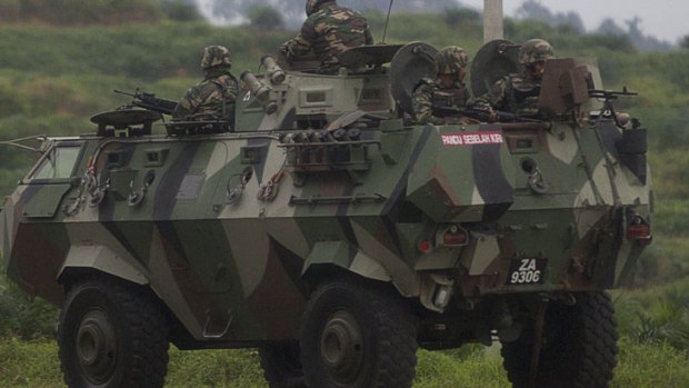 Malaysian soldiers with in an armored personnel carrier drive towards the area where the stand-off with Sulu gunmen is on going, in Tanduo village on March 4, 2013.