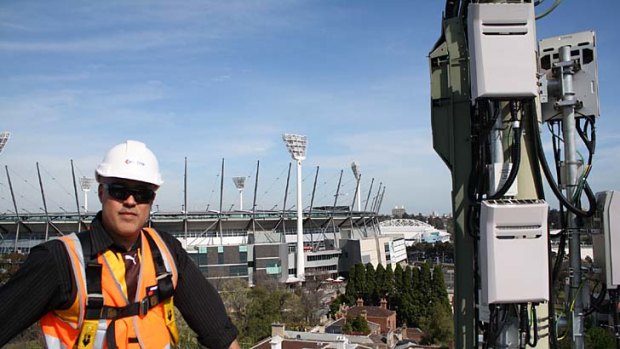 Telstra technician Alberto Vasquez adds network capacity around the MCG, where Telstra says it more than doubled its mobile network capacity ahead of the AFL Grand Final.