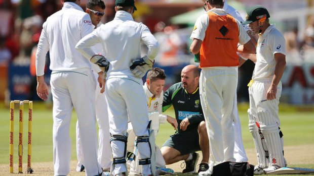 Michael Clarke receives treatment after getting hit by a delivery from Protezs paceman Morne Morkel.