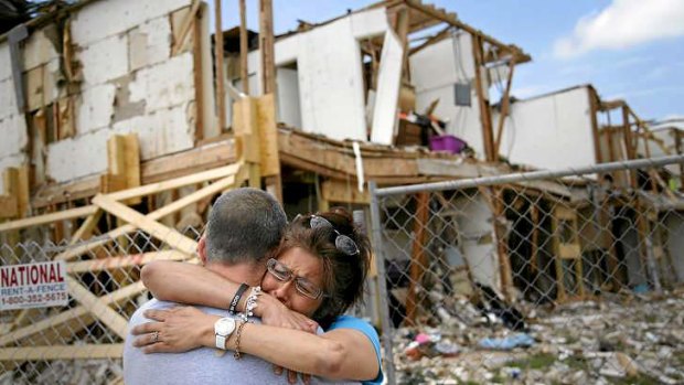 Shona Jupe, a resident of the apartment destroyed by the April 17 fertiliser plant explosion, hugs a friend while visiting the site.