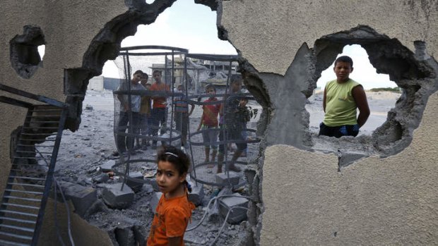 Palestinian Suma Abu Mahsen, 7, stands by a damaged wall of a house following an overnight Israeli missile strike on Gaza.