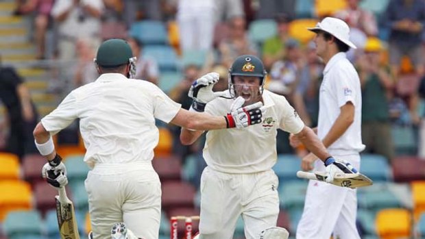 Michael Hussey (centre) celebrates his century with batting partner Brad Haddin during the third day of the first Test at the Gabba.