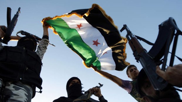 Syrian rebels brandish their weapons and a flag during a training session.