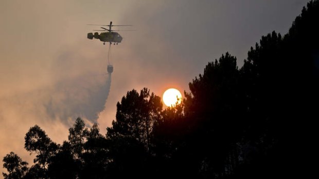 A helicopter drops water over a  fire in Talhadas, central Portugal.