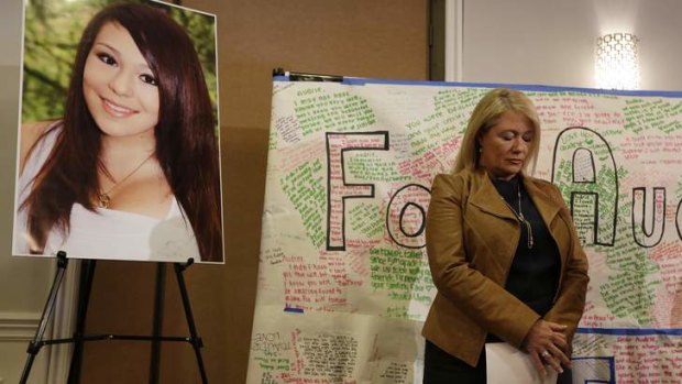 Sheila Pott, mother of Audrie Pott, stands by a photograph of her daughter during a news conference.