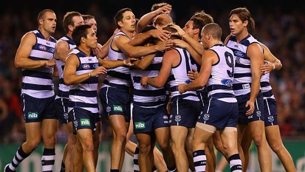 Jordan Schroder of the Cats is congratulated by his teammates after kicking a goal against Essendon.