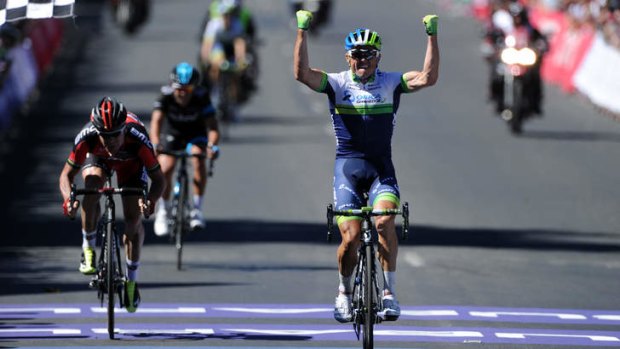Simon Gerrans raises his arms in triumph as he finishes ahead of Cadel Evans and Richie Porte.