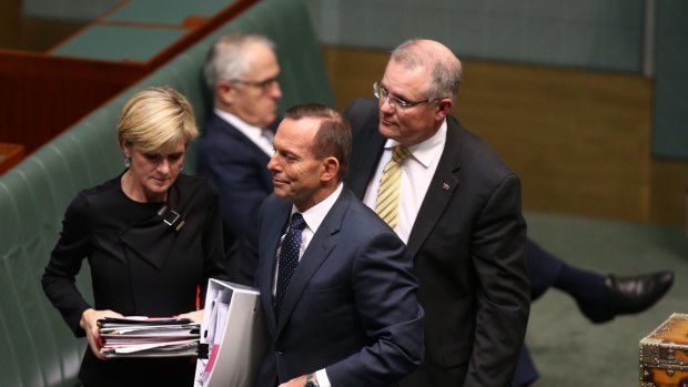 Prime Minister Tony Abbott departs question time with Julie Bishop and Scott Morrison while Malcolm Turnbull remains on the frontbench.