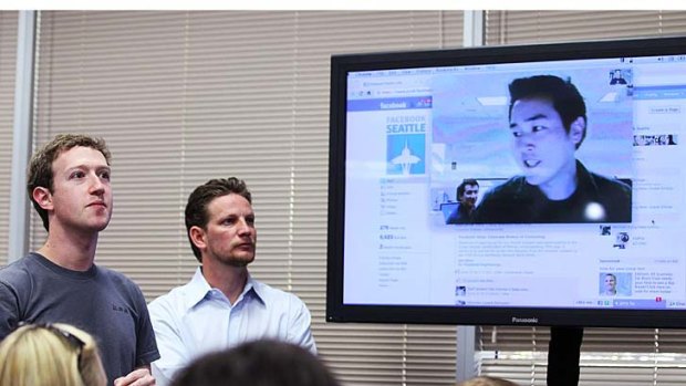 Facebook CEO Mark Zuckerberg, left, watches a demonstration of the new Facebook video chat during a news conference at Facebook headquarters.