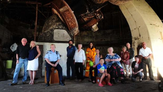 Pictured in the burnt-out shell of the 74-inch telescope dome at Mount Stromlo which was destroyed in the 2003 firestorm, from left, are: Barry and Denise McGloin, Jane MacKenzie, Graeme Blackman, Di Butcher, Nicole King, Hazel Bennett, Roy Arnould, Linda Thurbon, Gail and Laurence Buchanan, Alex Evans, and Eric Hayes.