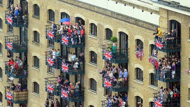 Spectators watch the flotilla from apartments by the Thames.
