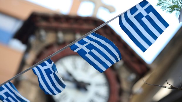 Greek national flag bunting hangs in front of a church in Athens on Thursday. Greek voters are split heading into a referendum European leaders said could plunge the country into economic darkness. 