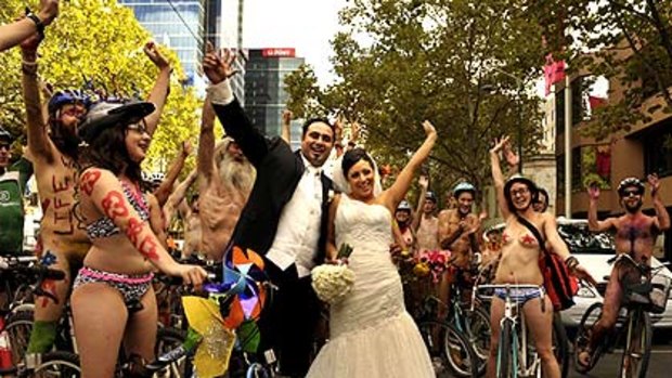 Members of Melbourne’s World Naked Bike Ride give newlyweds Laura and Angelo Puopolo a rousing reception in the city yesterday.