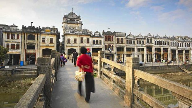 People crossing the bridge in front of colonial architecture, Chikanzhen, Guangdong.