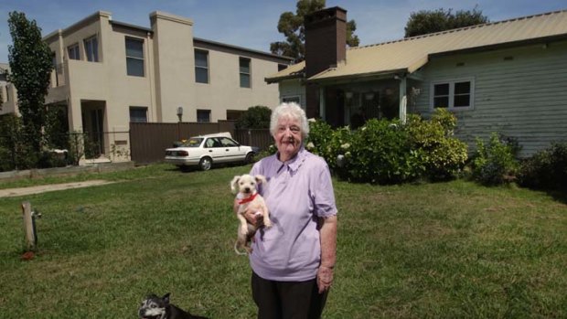Missing them &#8230; Beverley Smith and her dog, Casper, with her home and the Rudds' house in the background.