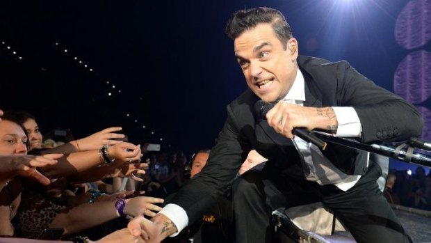 Robbie Williams interacts with  ecstatic members of the crowd in Brisbane.
