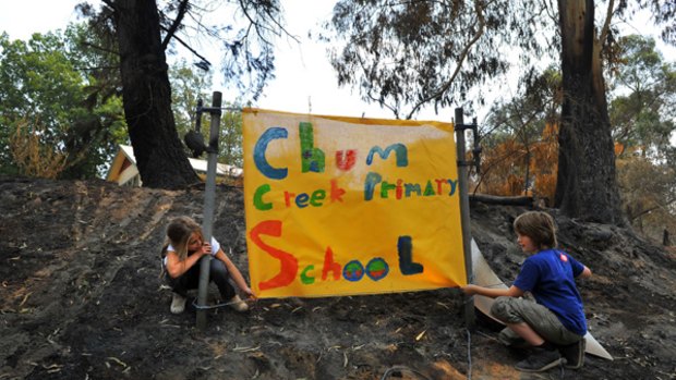 Tahlia Hayes and Sole Tate put up their new school sign which the students have made at Chum Creek Public School. The old sign burnt down during last week's bushfires.