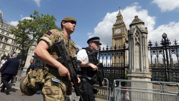 A member of the army joins police officers in Westminster after the Manchester bombing.