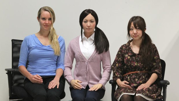 The 'girl' in the middle is Actroid-F, a robot designed to look, move and speak as we do.