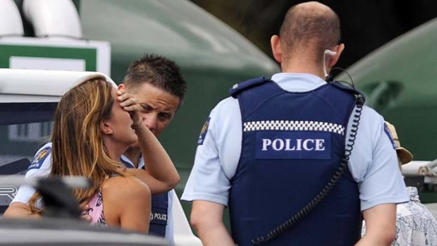 Police comfort a woman believed to be a family member of the victim.