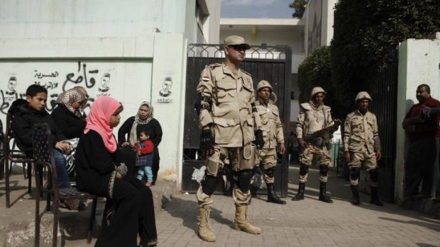 Egyptian army officers stand guard at a polling booth in the district of Imbaba.