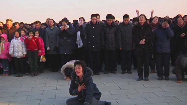 A woman cries near a statue of former North Korean leader Kim Il-sung.