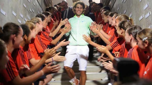 Rafael Nadal is applauded by ball boys and ball girls after his victory at Roland Garros.