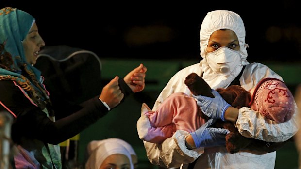 An Italian rescue worker carries a child rescued from a boat crammed with migrants in April. 