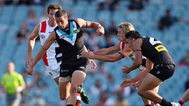 Tough contest: Port's Travis Boak goes hard at the ball at AAMI Stadium yesterday.