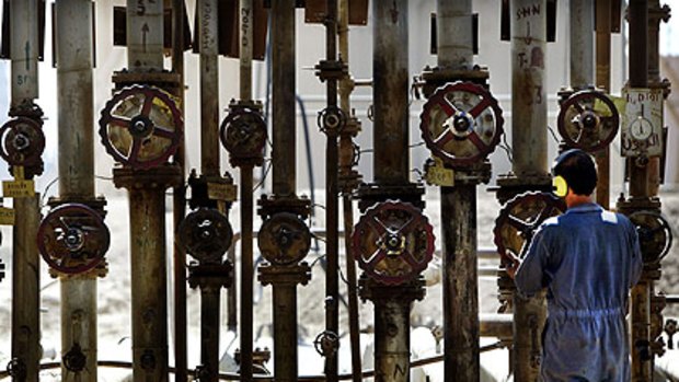 Pumping up dispute's volume ...  a worker checks valves at the al-Doura oil refinery outside Baghdad.