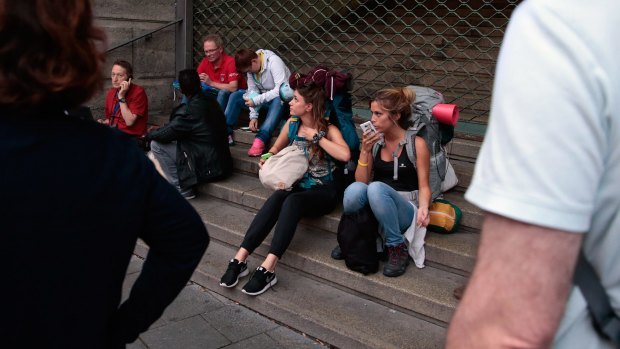 Stranded tourists wait in front of Munich Central train station, closed after the shooting.