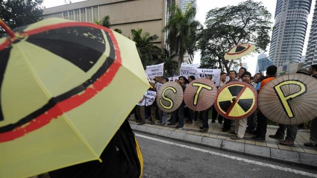 Activists hold umbrellas with anti-radiation symbols on them during a demonstration against the proposed rare earth plant, last year.