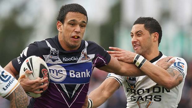 Storming run: Will Chambers fends off a tackle from Benji Marshall of the Wests Tigers during his previous stint at Melbourne Storm.