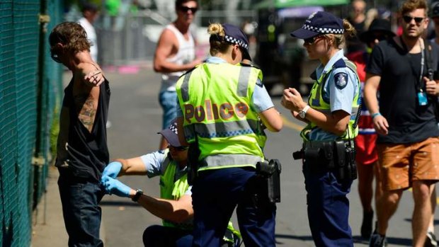 Police search a reveller at the Future Music Festival at Flemington Racecourse.