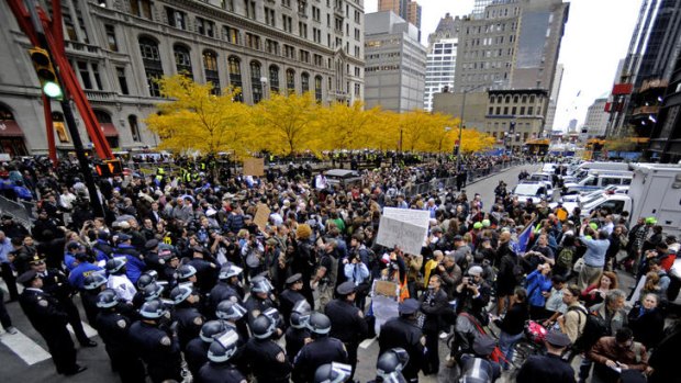 Members of the New York City Police Department (foreground) and protesters stand outside of Zuccotti Park in New York.