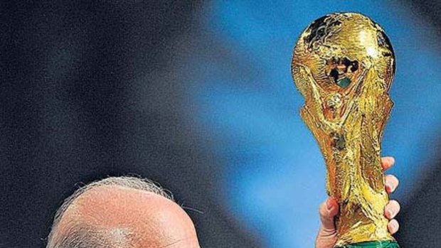 Sepp Blatter holds the World Cup during the draw for the 2010 tournament..