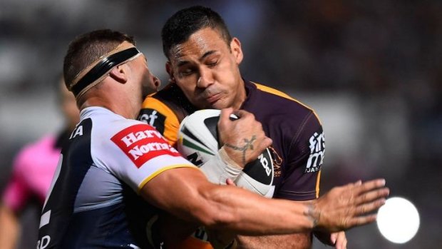 On report: Justin Hodges of the Broncos is tackled by Tariq Sims of the Cowboys.