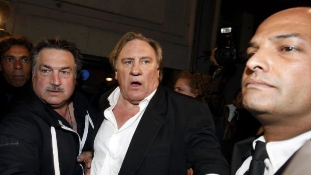 Gerard Depardieu leaves the screening of <i>Welcome to New York</i> in Cannes surrounded by bodyguards.