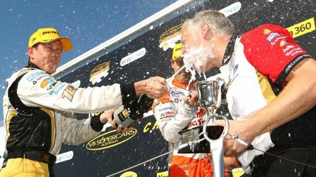 James Courtney (left) celebrates with chief engineer Adrian Burgess at the podium.