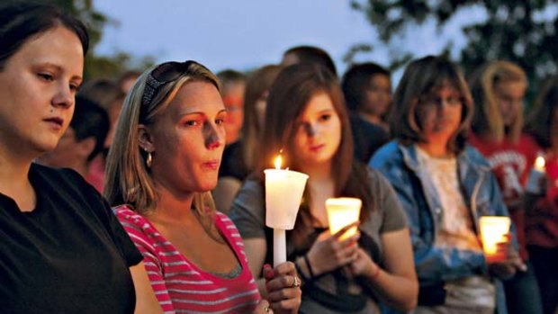 People gather for prayer at a candlelight vigil.