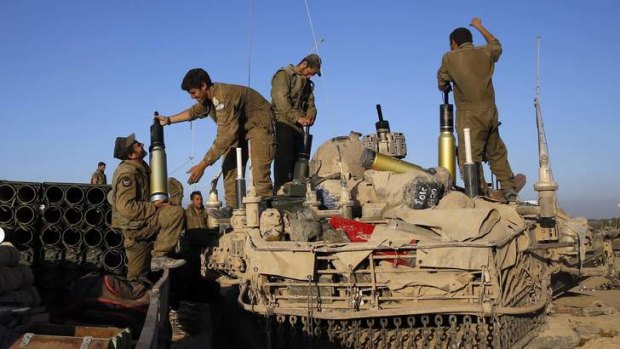 Israeli soldiers load shells on to a tank near the border of southern Gaza Strip.