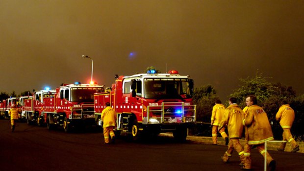 Under a glowering sky at Warrugal a firefighting team heads off to save houses.