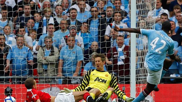 Get your Yaya out  ... Manchester City's Yaya Toure, right, slots the game winning goal past United goalie Edwin van der Sar. It was only City's second win over their bitter cross-town rivals in their past eight meetings.
