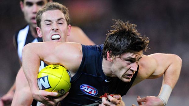 In arms way: Carlton's Nick Duigan tries to escape the clutches of Nick Maxwell.