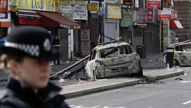 Burnt-out police cars litter a street in Tottenham.