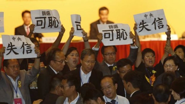 Pro-democracy legislators display placards in protest against the speech of Communist Party official Li Fei on Monday.