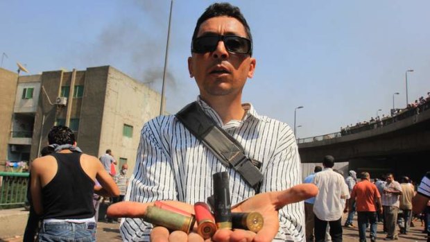 A supporters of Egypt's ousted President Mohamed Mursi shows spent ammunition during clashes with security forces near the largest sit-in by his supporters in Nasr City.