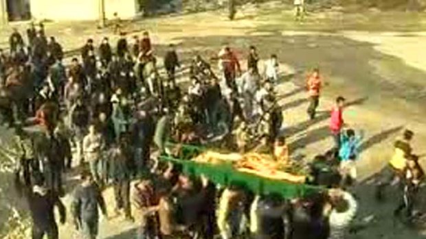 An image taken from a video uploaded on YouTube shows mourners carrying the coffin of a woman who was reportedly killed in the al-Hula region of central Homs.